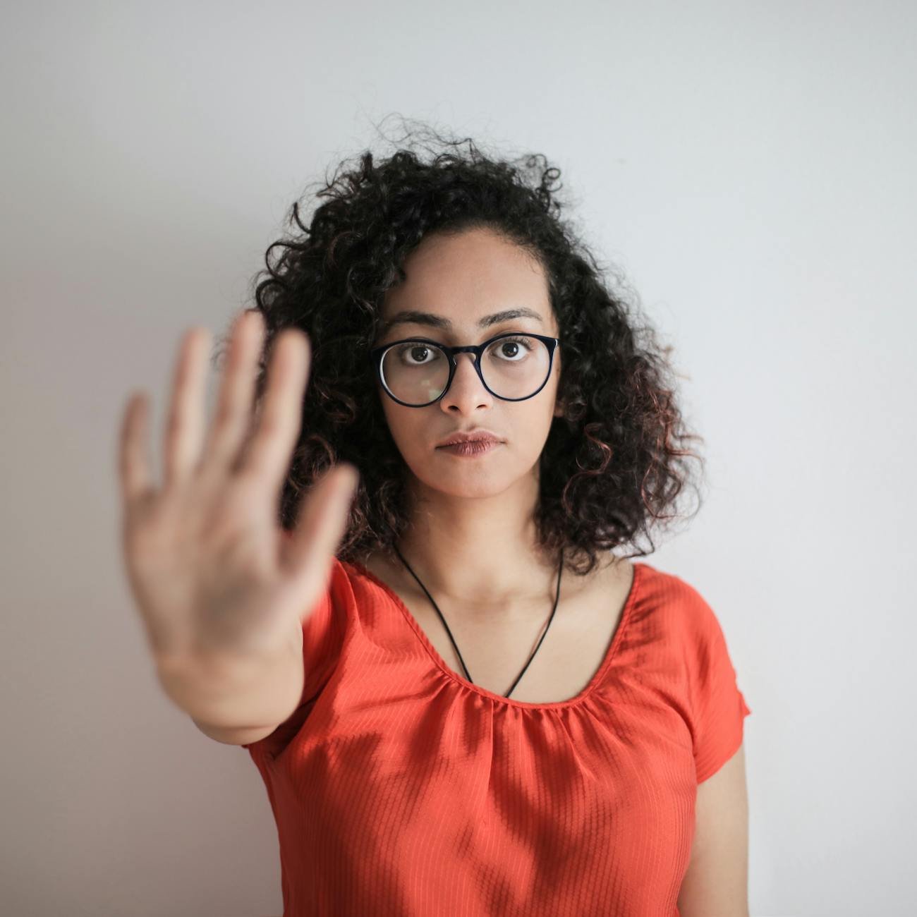 Photo by Andrea Piacquadio on <a href="https://www.pexels.com/photo/portrait-photo-of-woman-in-red-top-wearing-black-framed-eyeglasses-holding-out-her-hand-in-stop-gesture-3762802/" rel="nofollow">Pexels.com</a>