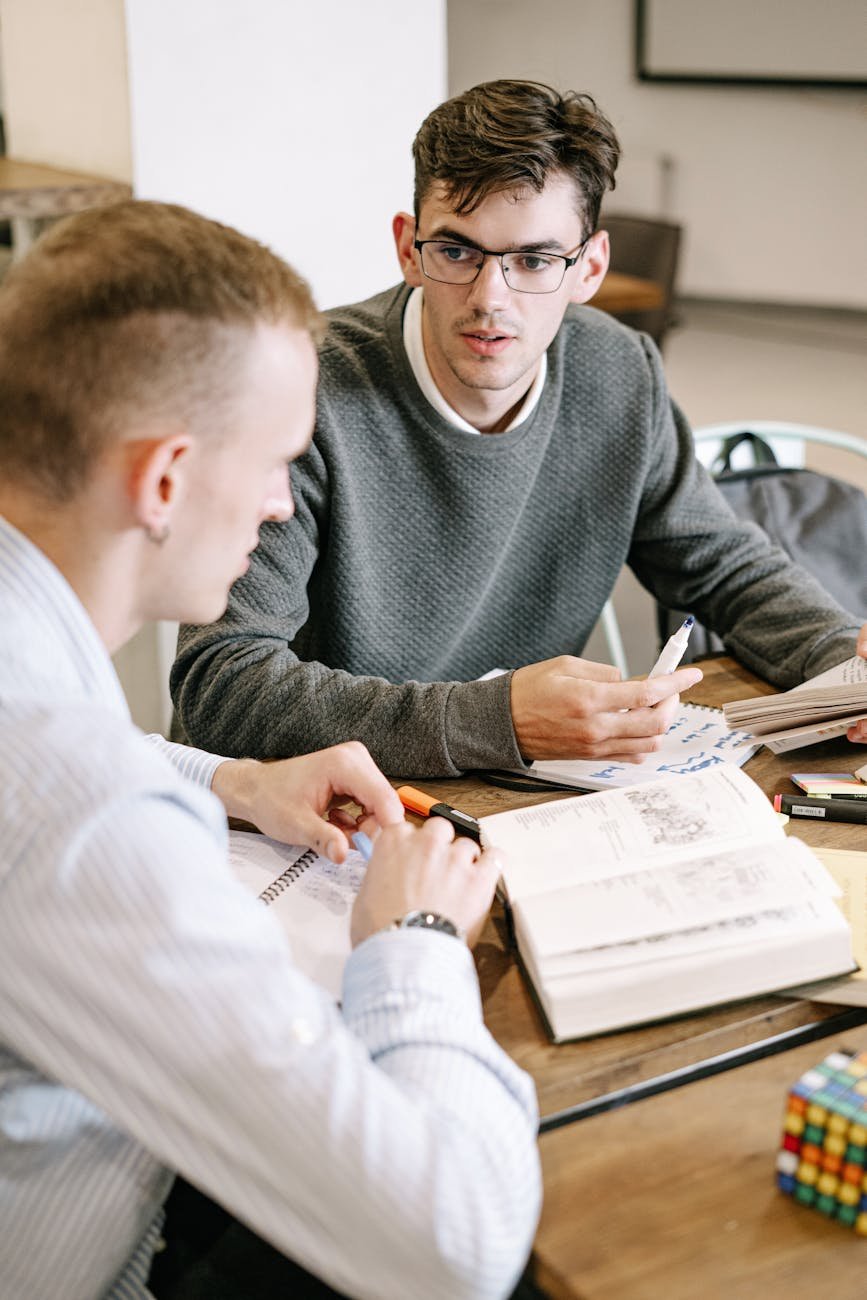 Photo by Ivan Samkov on <a href="https://www.pexels.com/photo/two-men-studying-together-5676678/" rel="nofollow">Pexels.com</a>